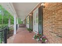 Inviting brick front porch with swing, potted plants and brick floor at 2508 Sevier St, Durham, NC 27705