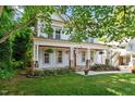 Inviting two-story home with a cozy front porch, green lawn, and mature trees at 2613 Bedford Ave, Raleigh, NC 27607