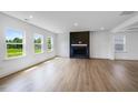 Spacious living room with wood floors, large windows, and a modern fireplace accent wall at 2625 Stonington Dr, Cary, NC 27523