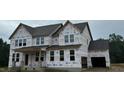 New construction home featuring a two-car garage and classic window design at 264 Alden Way, Angier, NC 27501