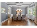 Elegant dining room with coffered ceiling, stylish chandelier, and ample seating at 2993 Club Dr, Raleigh, NC 27613