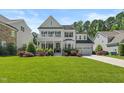 Charming two-story white home featuring a welcoming front porch and well-manicured lawn at 2993 Club Dr, Raleigh, NC 27613