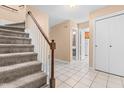 Inviting foyer featuring a carpeted staircase, neutral walls, and tile flooring, offering a bright entry at 3029 Wycliff Rd, Raleigh, NC 27607
