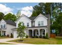 Charming two-story home boasts a covered front porch and manicured lawn at 303 Forestview Crest Way, Fuquay Varina, NC 27526