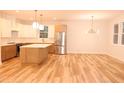 Spacious kitchen with stainless steel refrigerator and stylish lighting fixtures at 305 W Waddell St, Selma, NC 27576