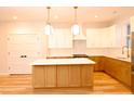Bright, modern kitchen featuring an island, white cabinets, and stainless steel appliances at 305 W Waddell St, Selma, NC 27576