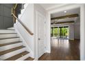 Bright foyer with hardwood floors, white trim, and open staircase to the upper level at 324 Prides Xing, Rolesville, NC 27571