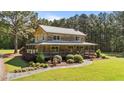 Beautiful log home featuring a covered porch and professional landscaping at 407 Howard Tant Rd, Zebulon, NC 27597