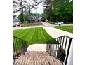 Inviting home exterior showcasing a well-manicured lawn, mature trees, and long driveway at 409 Eagle Ct, Henderson, NC 27536