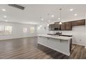 Bright, open kitchen with dark cabinets, granite countertops, and stainless steel appliances at 413 Providence Springs Ln, Fuquay Varina, NC 27526