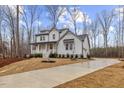 Charming two-story white home with a welcoming front porch, and a long driveway landscaped with pine straw at 42 Turkey Ct, Timberlake, NC 27583