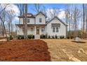 Charming two-story white home with a welcoming front porch and well-manicured lawn and landscaped with pine straw at 42 Turkey Ct, Timberlake, NC 27583