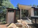 Modern home exterior showcasing stone accents, expansive windows, and a unique roofline set against a backdrop of lush trees at 481 Brook Green Ln # 23, Pittsboro, NC 27312