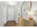 Inviting entryway with wood floors, a stylish cabinet, and a large round mirror, creating a warm welcome at 5009 Megara, Raleigh, NC 27603