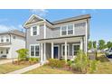 Beautiful home featuring gray siding, a cozy front porch with seating, and well-maintained landscaping at 5009 Megara, Raleigh, NC 27603