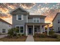 Two-story home with a welcoming front porch, blue door and landscaped front yard at 5009 Megara Run, Raleigh, NC 27603