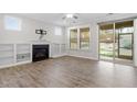 Bright living room featuring a fireplace, built-in shelves, large windows, and a sliding door to the outdoor space at 52 Brunello Ct, Clayton, NC 27527