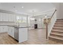 Open-concept living space with bright white walls, hardwood floors, and a staircase leading to the upper level at 52 Brunello Ct, Clayton, NC 27527