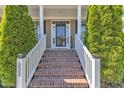 Charming home featuring brick steps, white pillars, and manicured greenery leading to the front door at 533 Opposition Way, Wake Forest, NC 27587