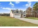Side view of this charming home with well-kept lawn and paved driveway at 56 Birchtop Cir, Zebulon, NC 27597