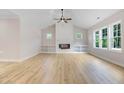 Bright living room features a shiplap fireplace, built-in shelves, and wood-look floors at 56 Birchtop Cir, Zebulon, NC 27597