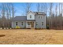 Charming two-story home featuring gray siding, black roof, and a cozy front porch with white railings at 596 Oaks Lane Rd, Timberlake, NC 27583