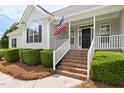 Inviting front porch with classic white railings and brick steps, creating a warm and welcoming entrance to the home at 608 Elin Ct, Hillsborough, NC 27278