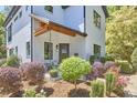 The covered front porch has a seating area and is surrounded by attractive landscaping at 631 Linfield Dr, Durham, NC 27701