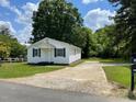 Quaint single-story house featuring white siding, blue shutters, and a long driveway at 703 W Church St, Angier, NC 27501