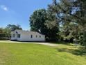 Exterior view of the house showing the large green yard and driveway at 703 W Church St, Angier, NC 27501