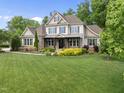 Stunning two-story house boasts a lush green lawn and mature trees in a serene setting at 7312 Hasentree Way, Wake Forest, NC 27587