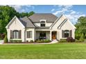 Charming two-story white brick home featuring manicured landscaping and a welcoming front porch at 8017 Discovery Falls Trl, Wake Forest, NC 27587