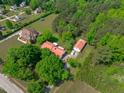Expansive aerial view of a property with lush greenery, showcasing a home with an adjacent structure and a red roof at 9108 Ransdell Rd, Raleigh, NC 27603