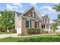 Brick home featuring an attached two-car garage with siding, nicely maintained shrubs, and a sidewalk at 9251 Palm Bay Cir, Raleigh, NC 27617