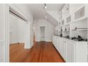 Spacious hallway with hardwood floors, large built in shelving unit, and white trim throughout at 1000 Lamond Ave, Durham, NC 27701