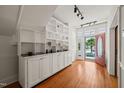 Hallway featuring hardwood floors, white trim, a built in shelving unit and front door view at 1000 Lamond Ave, Durham, NC 27701