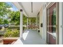 View of the welcoming covered porch featuring a porch swing, white columns, and a view of the front yard at 1000 Lamond Ave, Durham, NC 27701