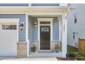 Inviting home entrance with decorative brick accents, black door, and well-maintained landscaping at 1021 Greatland Rd, Durham, NC 27703
