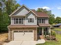 Charming two-story home with stone accents, gray siding, and a well-manicured lawn at 104 Anderson Park Dr, Wake Forest, NC 27596
