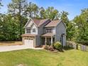 Charming two-story home with stone accents, gray siding, and a well-manicured lawn and fenced-in backyard at 104 Anderson Park Dr, Wake Forest, NC 27596