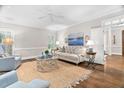 Cozy living room with hardwood floors, a ceiling fan, shutters and a neutral-toned couch at 106 Clendenen Ct, Cary, NC 27513