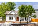 Charming white cottage-style home with a peaked roof, orange front door, and a cozy front porch at 107 N Guthrie Ave, Durham, NC 27703
