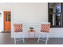 Front porch shows modern outdoor seating with orange accents next to the door at 107 N Guthrie Ave, Durham, NC 27703