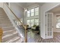 Bright foyer with a staircase, large windows, and an open floor plan into the living area at 110 Bristolwood Cir, Morrisville, NC 27560