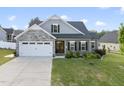 Charming home with stone accents, a two-car garage, and a well-manicured front yard with landscaping at 110 Deacon Ridge Ln, Youngsville, NC 27596