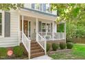 Inviting front porch with white railings, brick accents, and a cozy swing for relaxing outdoors at 110 Ferris Wheel Ct, Cary, NC 27513