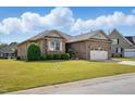 Classic brick home featuring lush lawn and a practical two-car garage at 116 Colonade Ct, Benson, NC 27504