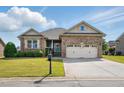 Inviting brick home with manicured lawn, complemented by a spacious driveway and two-car garage at 116 Colonade Ct, Benson, NC 27504