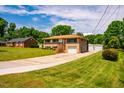 Traditional brick home with an attached garage and a long driveway, surrounded by mature trees at 117 Castlerock Dr, Durham, NC 27713