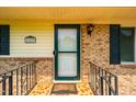 Close-up of the front door featuring a decorative tiled porch and a black wrought iron railing at 117 Castlerock Dr, Durham, NC 27713